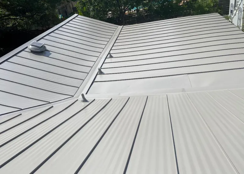 Solar attic fan installed on a metal roof for Roof Ventilation in Kenai