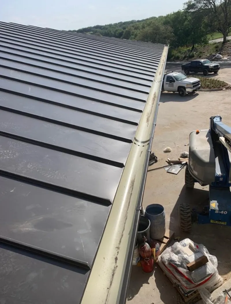Standing seam panel and gutter detail on a metal roofing jobsite in Kenai